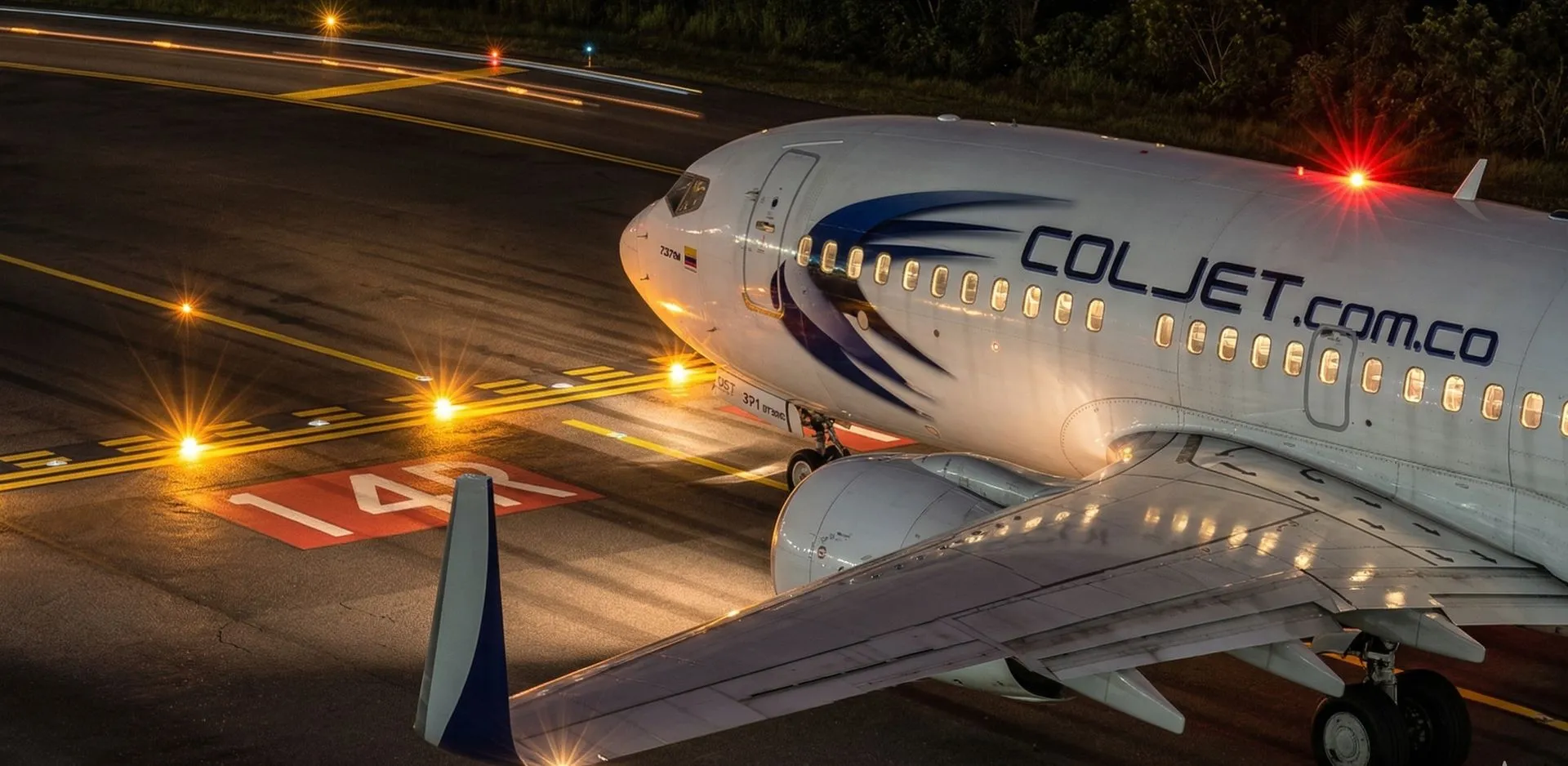 Boeing 737 de COLJET rodando de noche junto a la pista