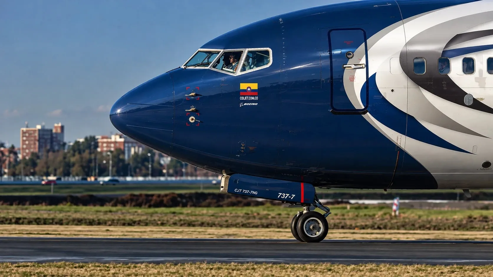 Nariz de un Boeing 737-700 de COLJET rodando de día en la pista